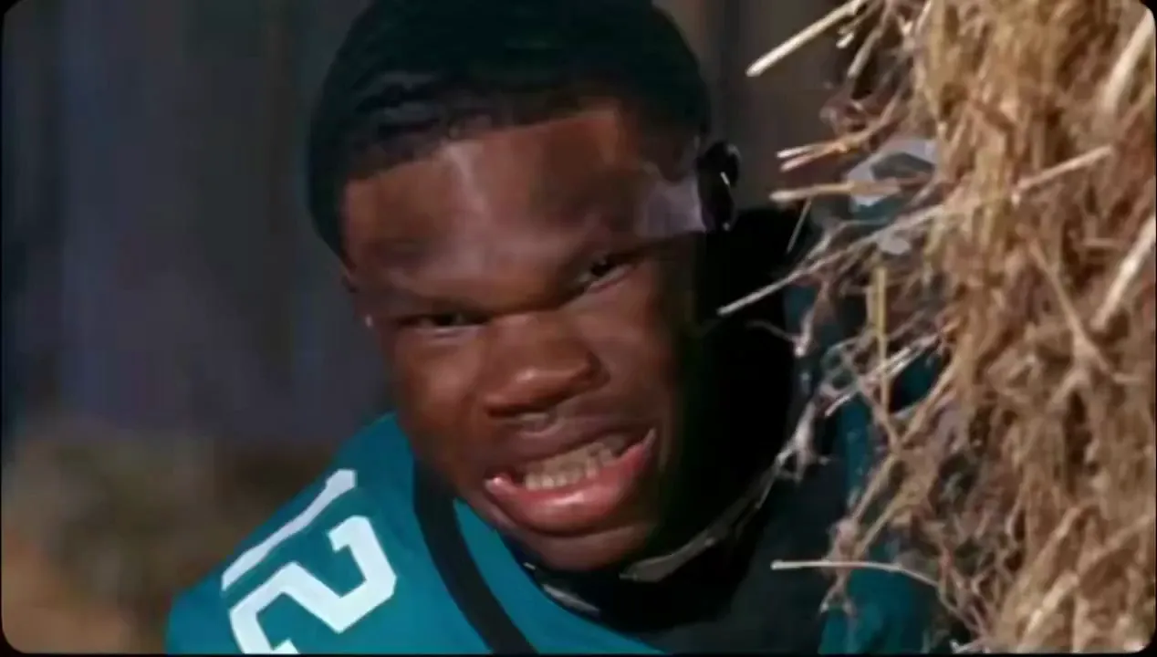 AI Rumpelstiltskin tiptoe dance: a football player in uniform shushes the camera in the barn
